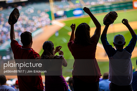 Family cheering on a baseball game at a sports stadium.