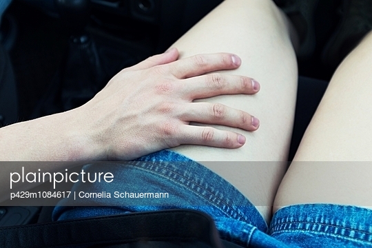 Young mans hand on young womans thigh