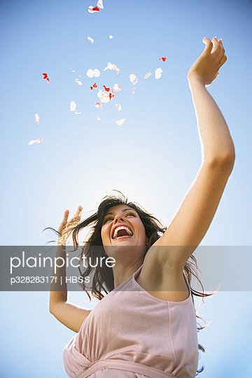 Woman throwing flower petals in the air