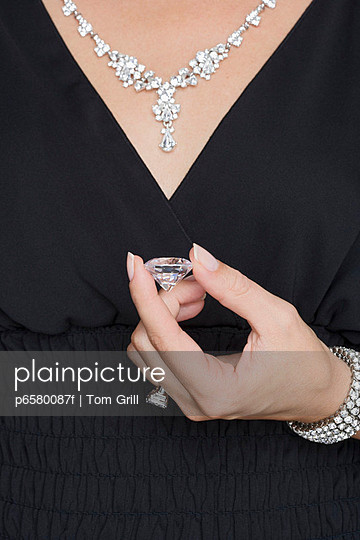 Woman with Diamond Jewelry Holding a Loose Diamond