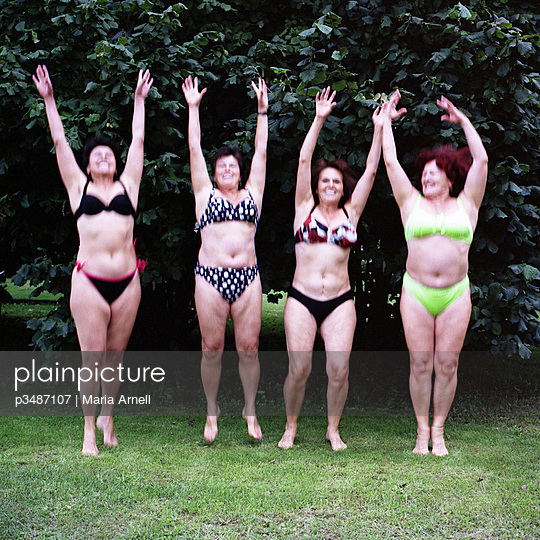 Four women in bikini jumping upwards