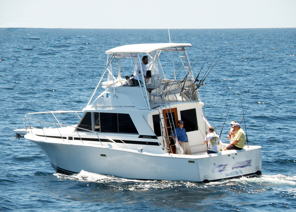 5 men with fishing poles in a small boat out in the sanctuary