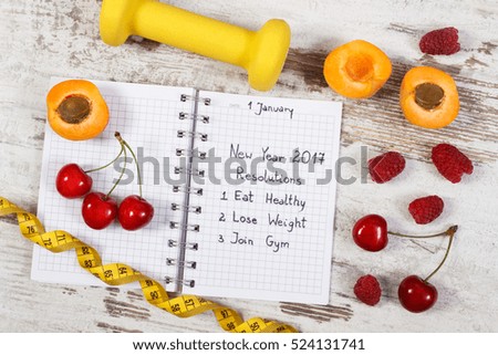 New year resolutions or goals eat healthy, lose weight and join gym written in notebook, fresh fruits, dumbbells for fitness and tape measure