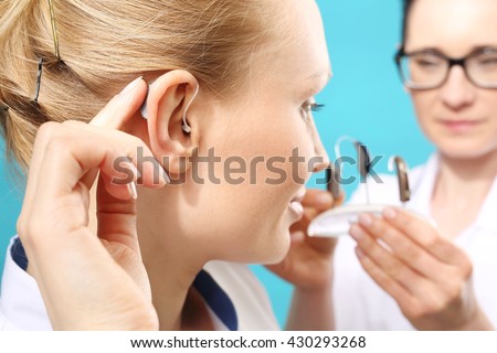 Hearing aid. The doctor assumes the woman hearing aid in your ear