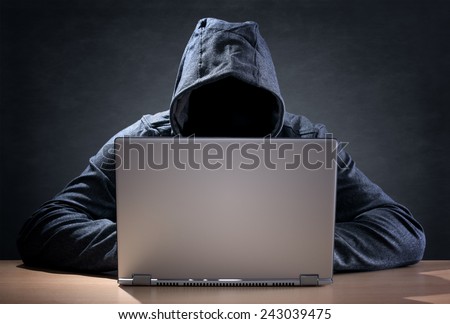 Computer hacker stealing data from a laptop concept for network security, identity theft and computer crime