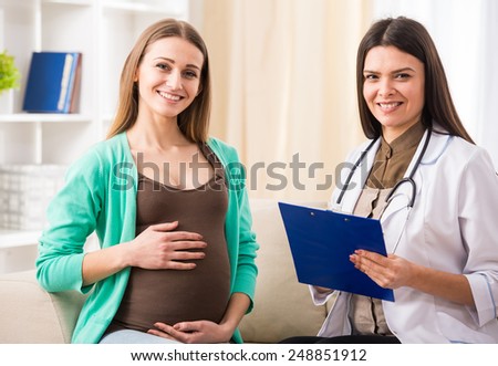 Consultation of pregnant young woman with doctor in hospital.