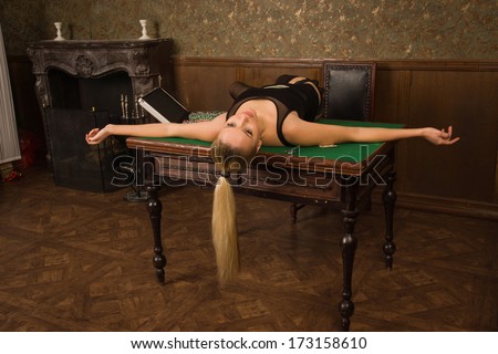 Crime scene simulation. Lifeless woman in a luxurious lingerie lying on the casino table