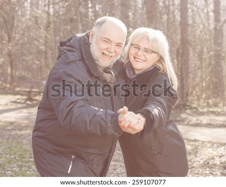 Happy Elderly Senior Romantic Couple holding hands in nature, Old people portrait outdoor winter autumn season.