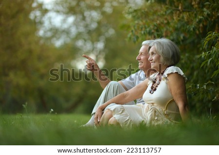 Beautiful happy old people sitting in the autumn park