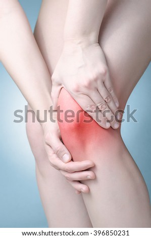 A young woman massaging her painful knee