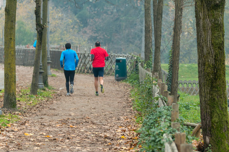 Two men jogging in park in autumn. Health and fitness