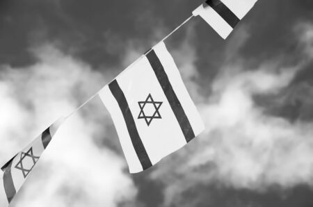 Israel flags in a chain in white and blue showing the Star of David hanging proudly for Israel\'s Independence Day (Yom Haatzmaut) - black and white