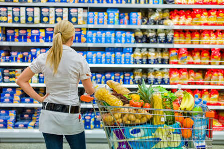 a woman is overwhelmed with the wide range in the supermarket when shopping