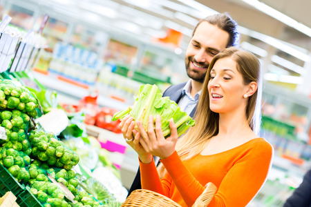 Couple selecting vegetables while grocery shopping in supermarket