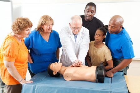 Doctor demonstrates CPR for and adult education class on first aid.