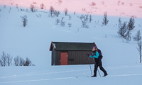 Skiing past Trollvassbu at sunset