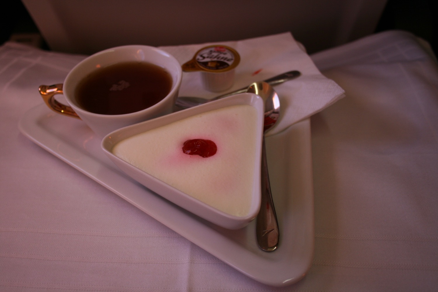 a plate with a cup of tea and a dessert on it