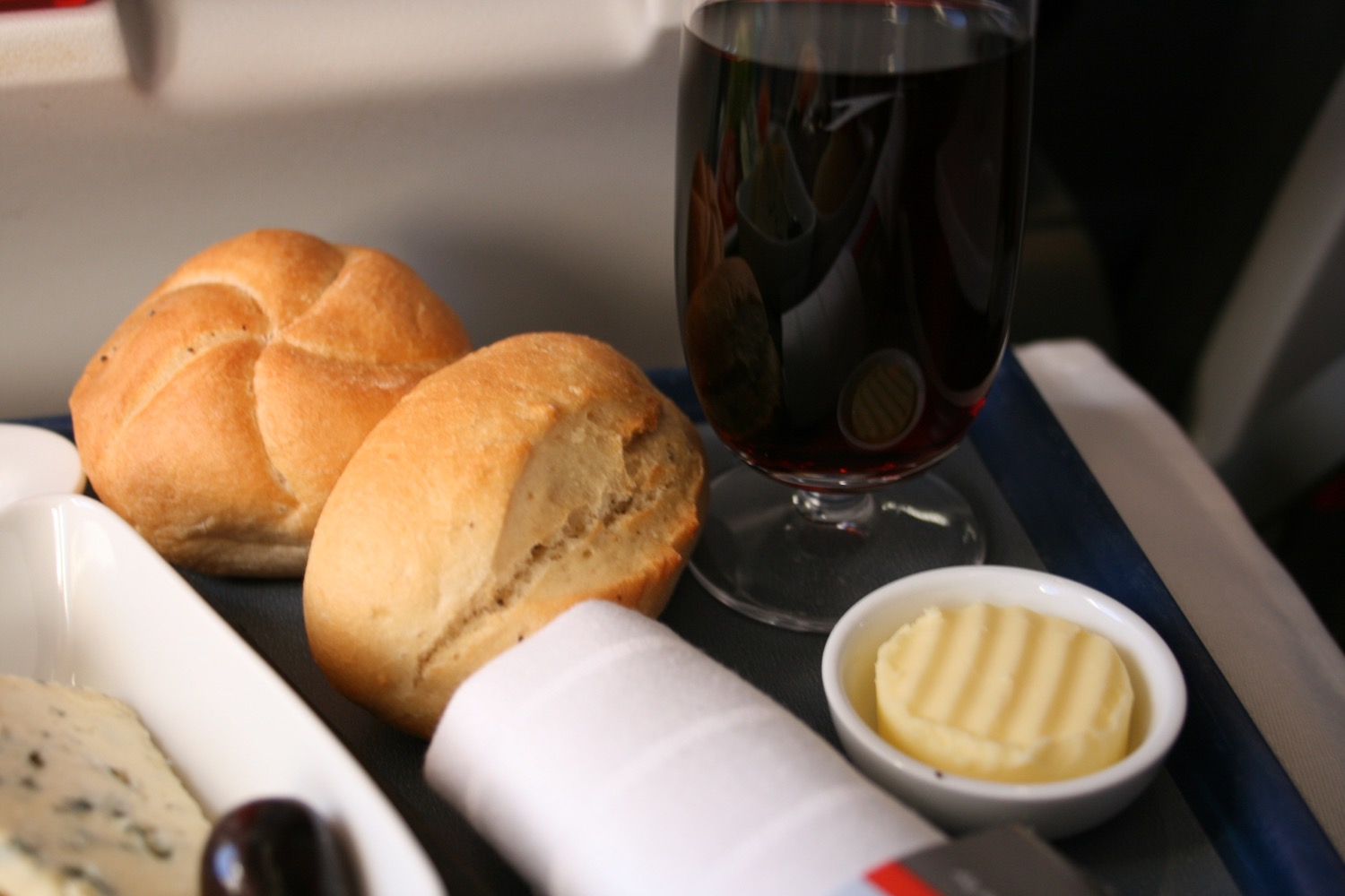 food on a tray with a glass of wine