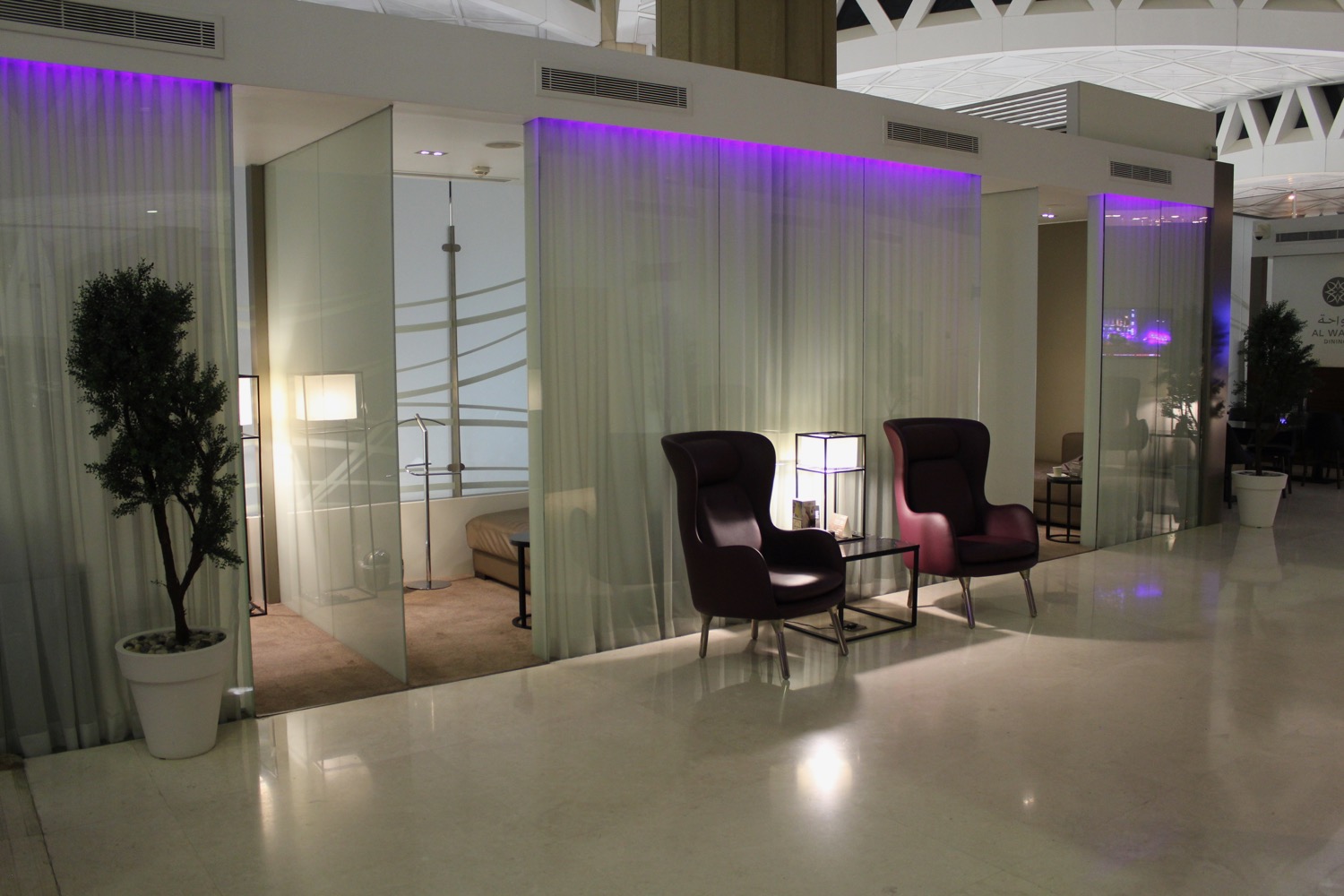 a room with purple lights and chairs