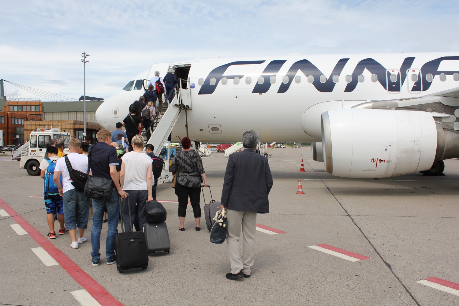 people boarding an airplane with luggage