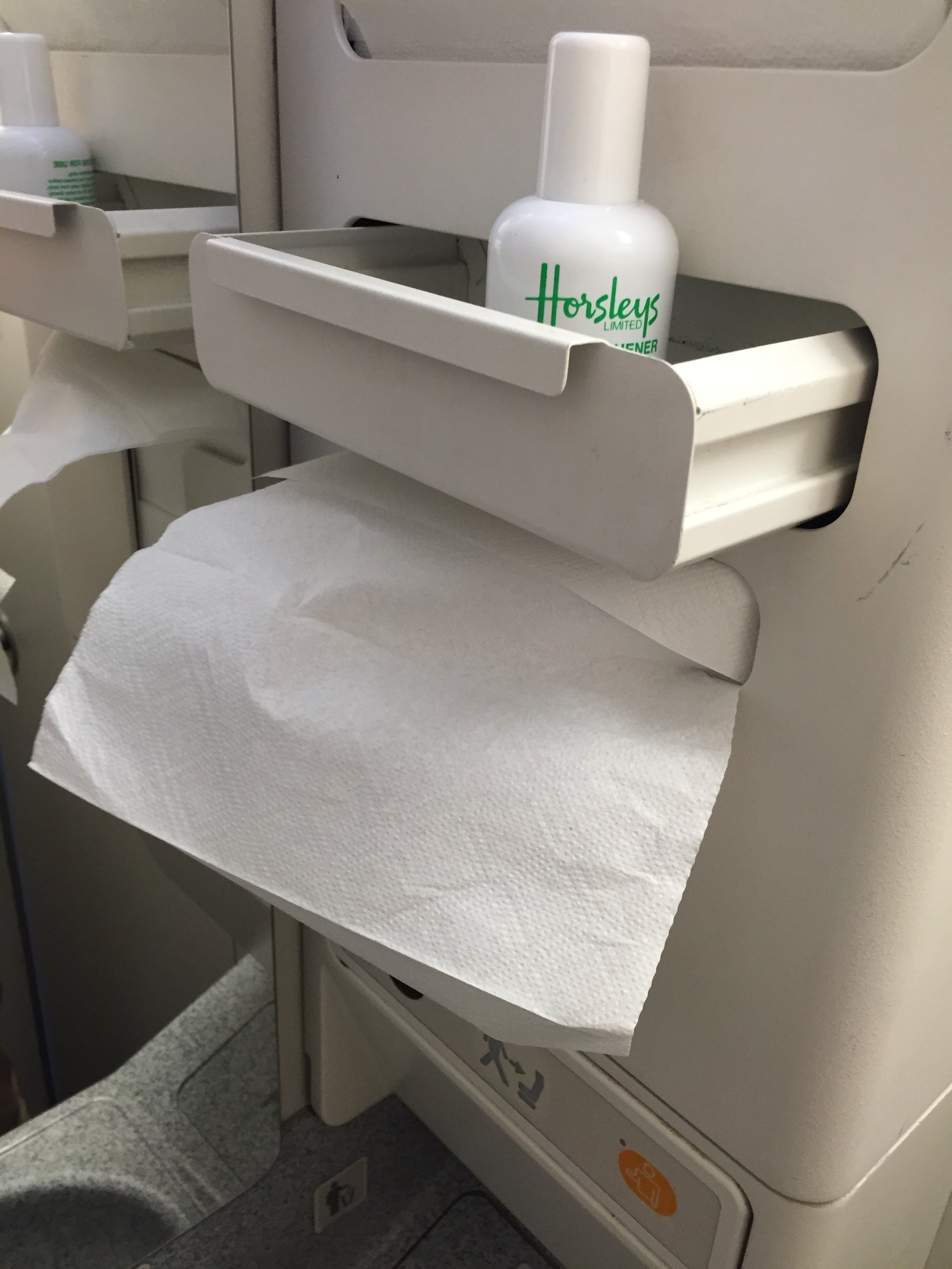 a white drawer with a white container with a white bottle of hand sanitizer and a tissue paper on it