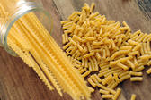 a selection of pasta including macaroni on a wood countertop