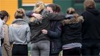 Students hug in front of the Joseph-Koenig-Gymnasium high school in Haltern am See 