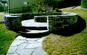 Circular Rundle Stone Retaining Wall, Raised Rundle Stone Patio, Rundle Stone Sidewalk & Brick BBQ Pit