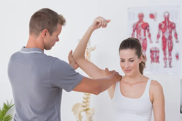 Doctor stretching woman arm