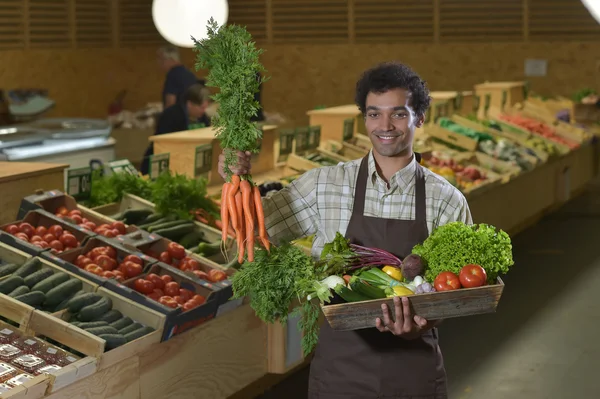 Grocery clerk working in produce aisle of supermarket store