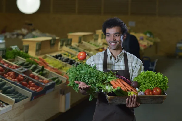 Grocery clerk working in produce aisle of supermarket store