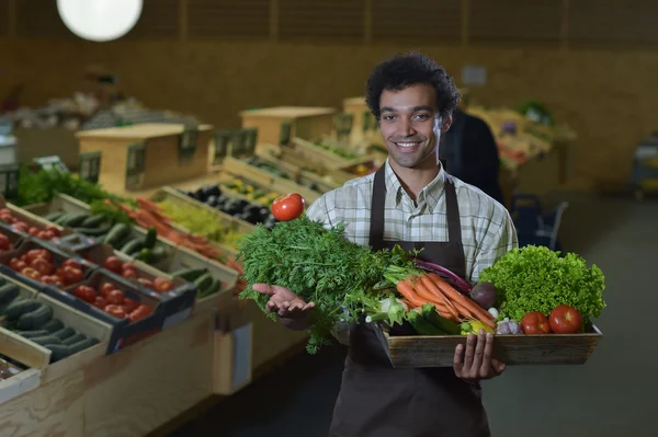 Grocery clerk working in produce aisle of supermarket store