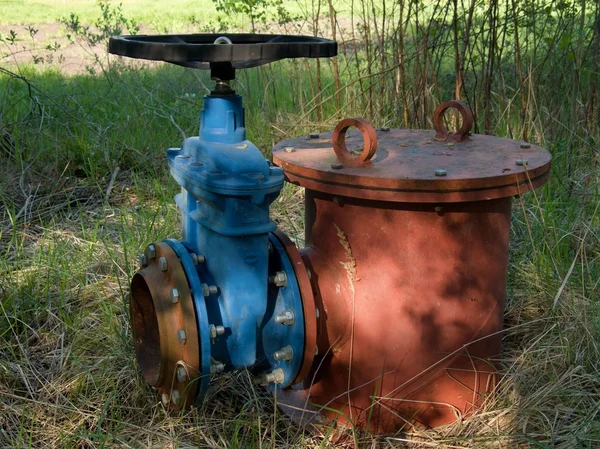 Old expansion pipe of drink water pipes joined with new blue valve and new blue joint members. New dump valve. Extreme kind of corrosion, metal corroded texture.