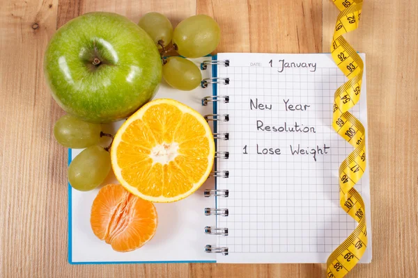 New years resolutions written in notebook and tape measure