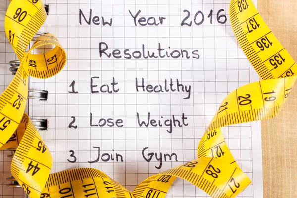 New years resolutions written in notebook and tape measure