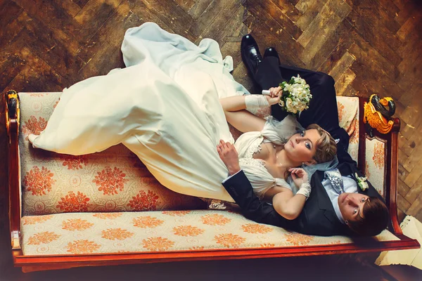 Bride lays on groom\'s knees