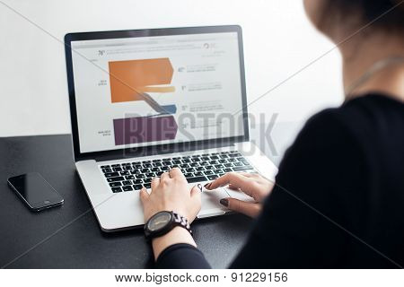 Shot of a young lady working with laptop, woman\'s hands on notebook computer and smart phone, buisin