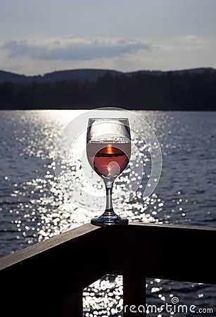 Glass of red wine at lake