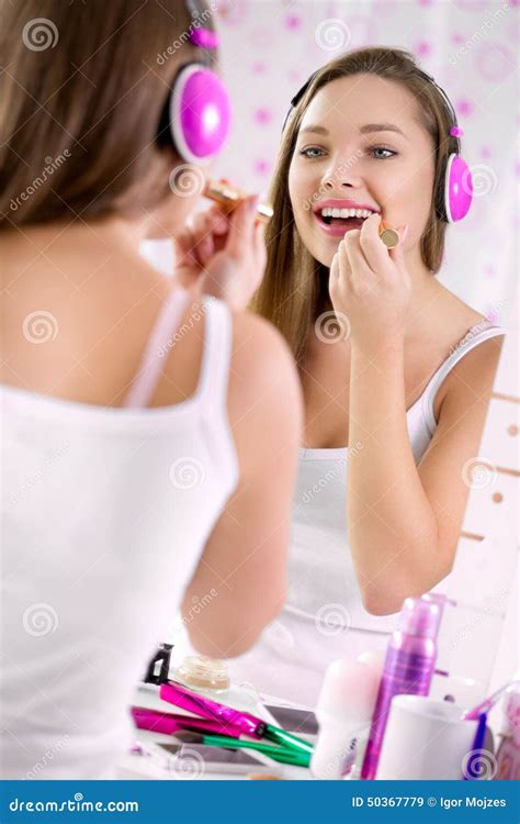 Teenage Girl Applying Make Up and Looking in the Mirror, Stock Image ...