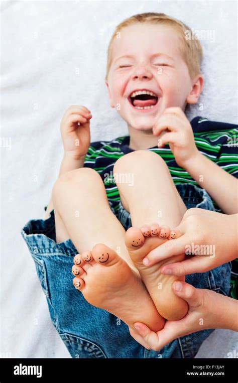 child laughing hysterically while getting feet tickled Stock Photo - Alamy