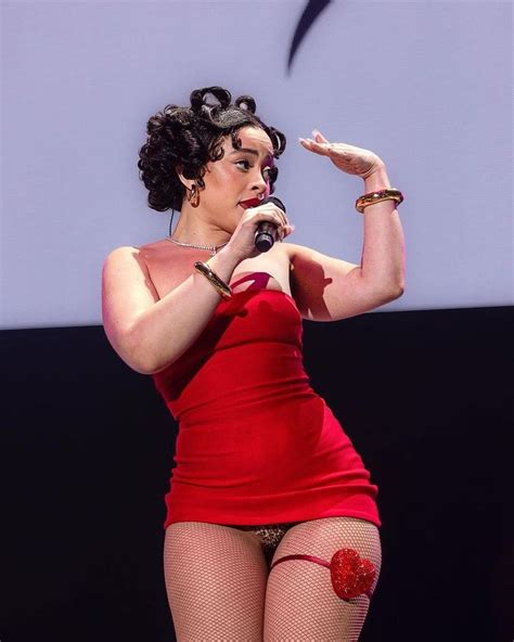 a woman in a red dress is holding a microphone and wearing fishnet tights