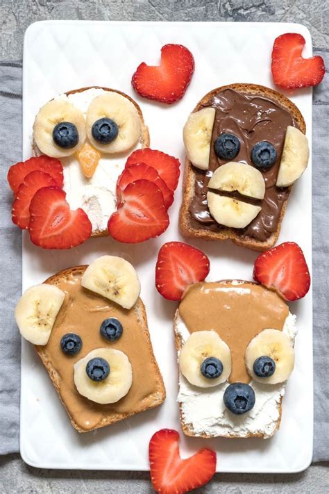 two slices of toast with peanut butter, bananas and strawberries on ...