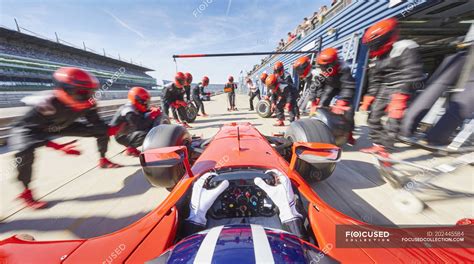 Pit crew ready for formula one race car in pit stop — red, track ...