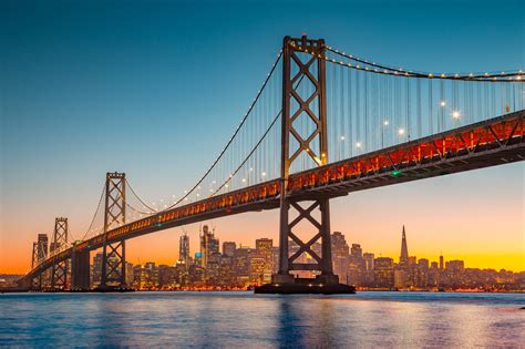 San Francisco skyline with Oakland Bay Bridge at sunset, California ...