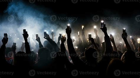 Group of people holding cigarette lighters and mobile phones at a ...