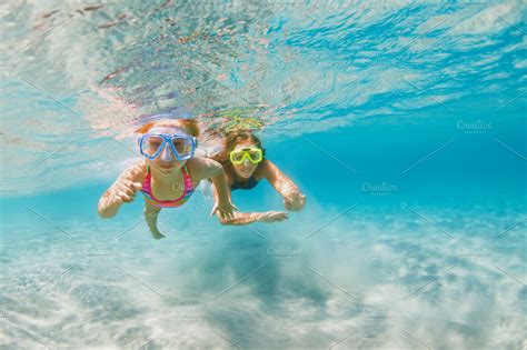 Family snorkeling in tropical sea featuring family, snorkel, and ...