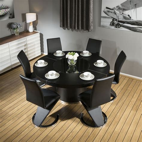 a dining room table with black chairs and white plates