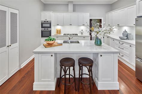 a kitchen with white cabinets and wooden floors