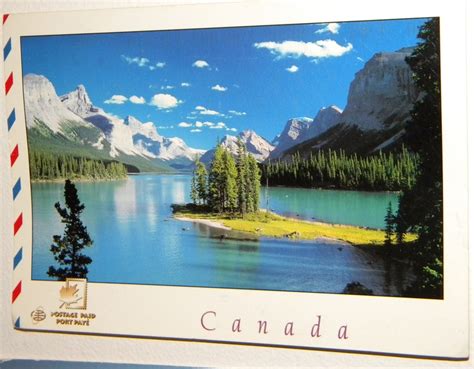 a postcard with an image of a lake and mountains in canada on it's side