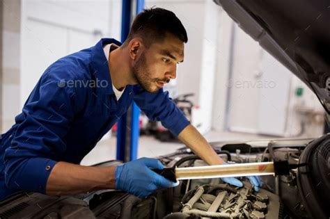 Car Service: Auto Mechanic Man Repairing Car at Workshop